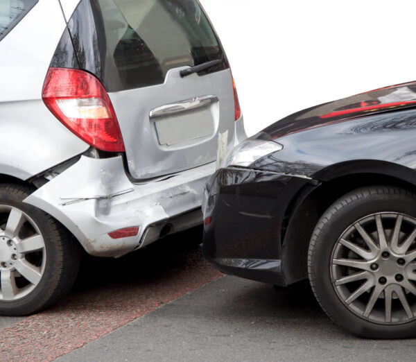 close up of silver and black car involved in collision