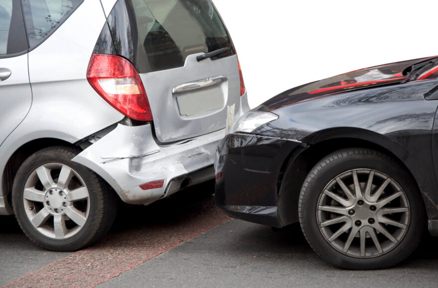 close up of silver and black car involved in collision